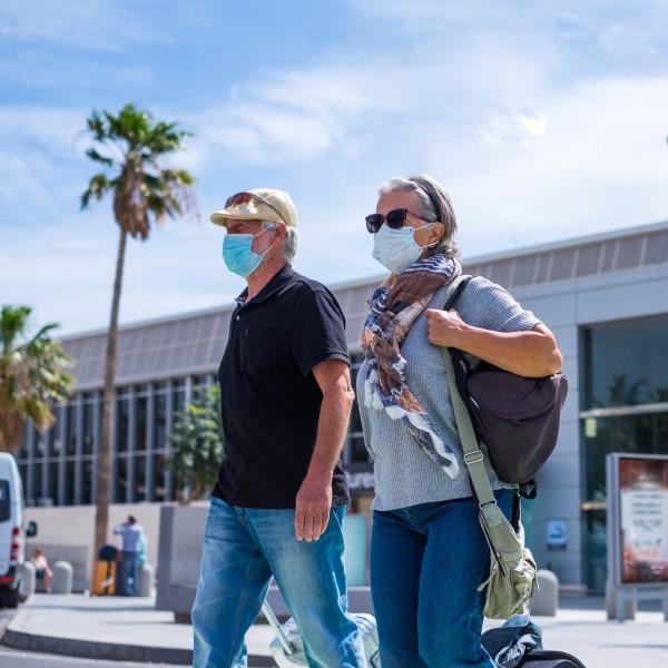 masked travelers at airport