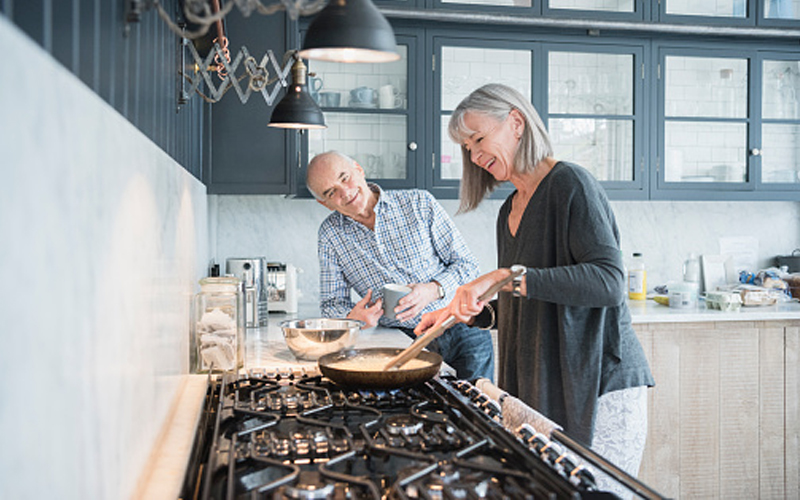 Middle age couple cooking in kitchen