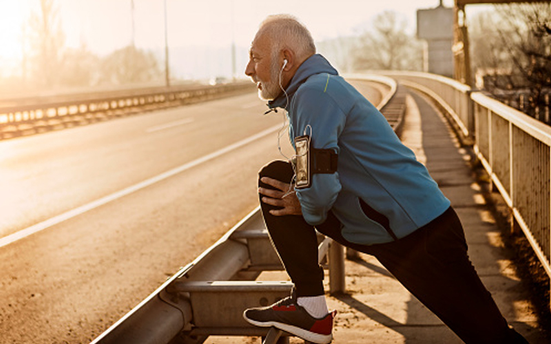 Middle aged runner stretching