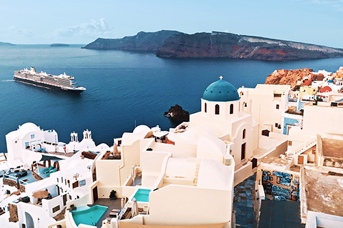 a cruise ship approaches Cycladic houses