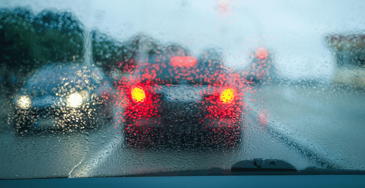 The view out of a car windshield on a rainy day