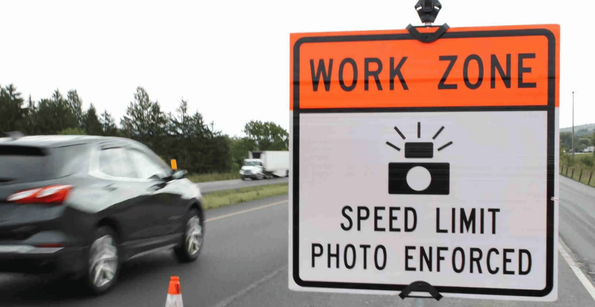 a sign on the road that reads Work Zone Speed Limit Photo Enforced