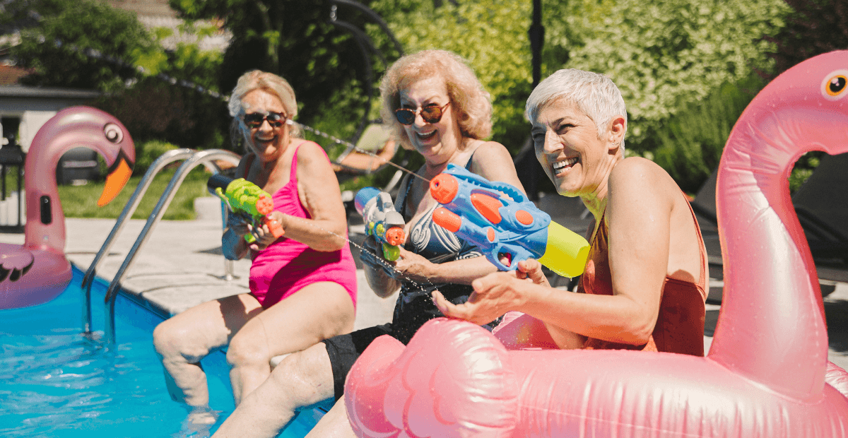Three older women have fun by the pool