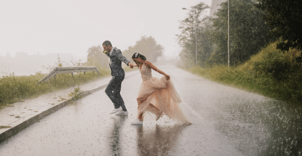 A bride and groom in a rainstorm
