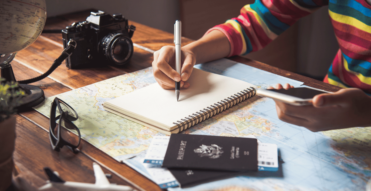 A woman sitting at a desk with travel planning materials
