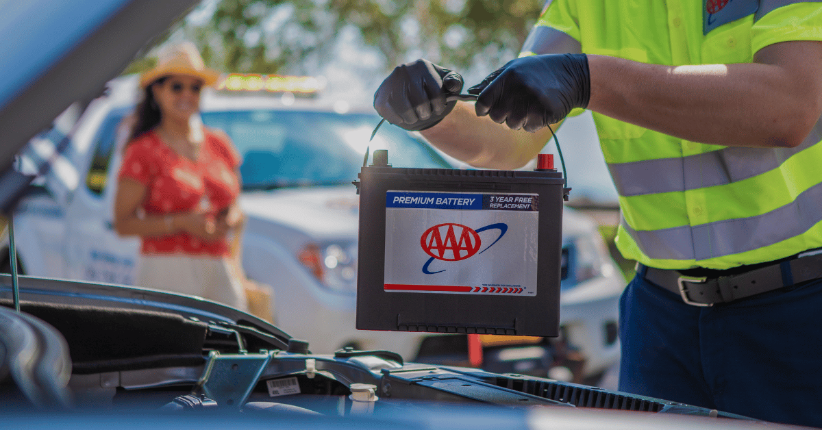 A AAA technician installs a new car battery