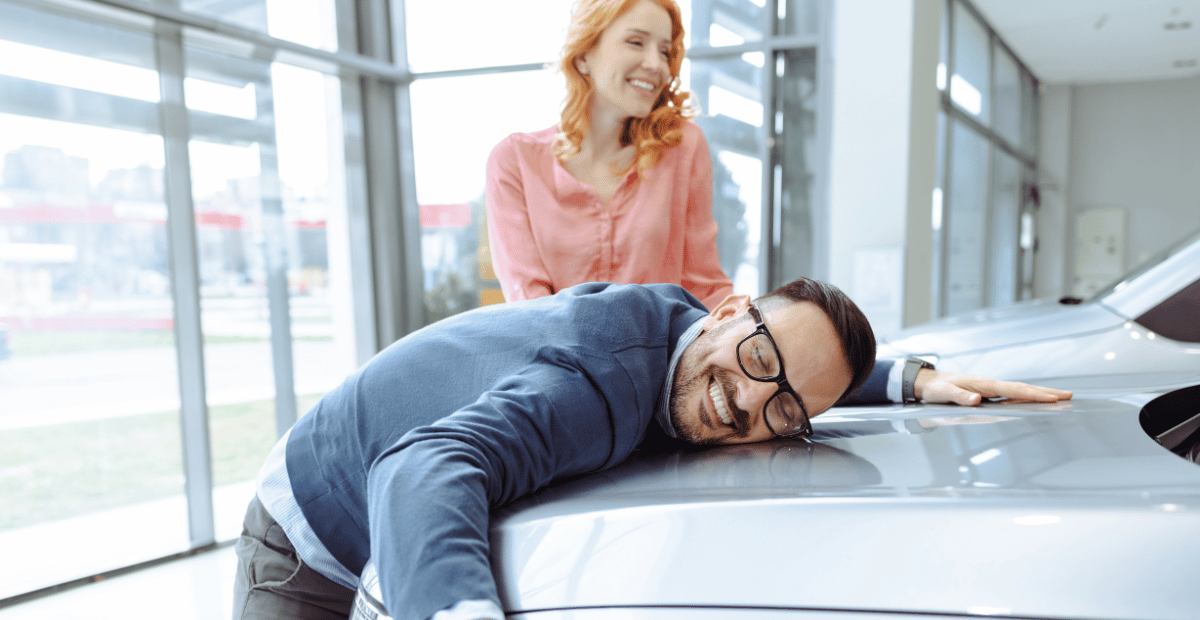 A man hugging a new car