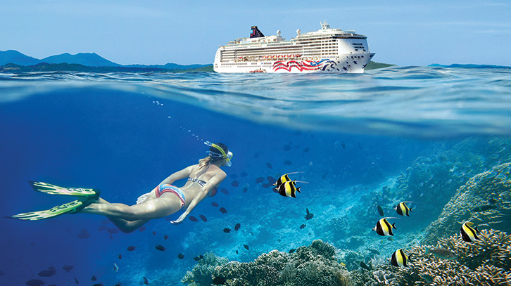a snorkeler explore the sea near a cruise ship