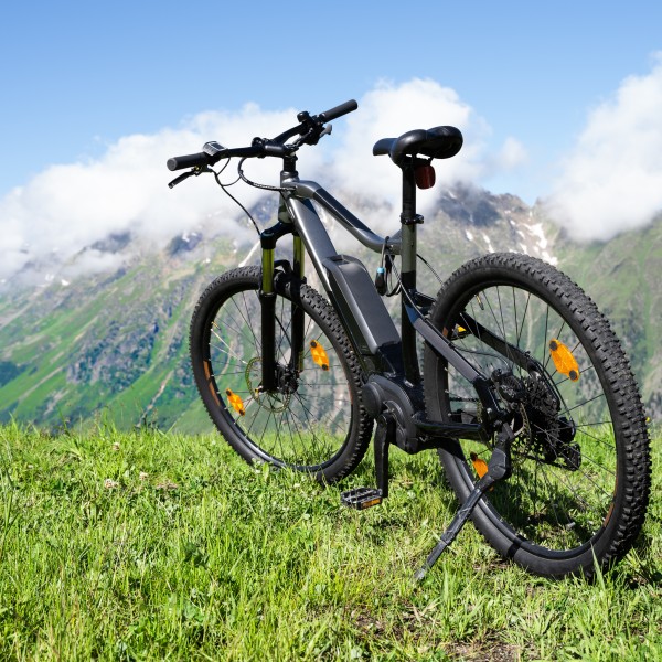 Adobe stock image of an electric bike in a field overlooking a scenic view of mountains.